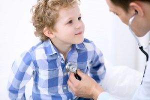 doctor examines little boy showing that medical and dental health insturance is important